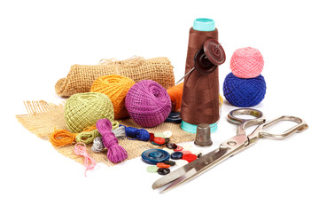 Thread, buttons, scissors on white background. Sewing supplies. 