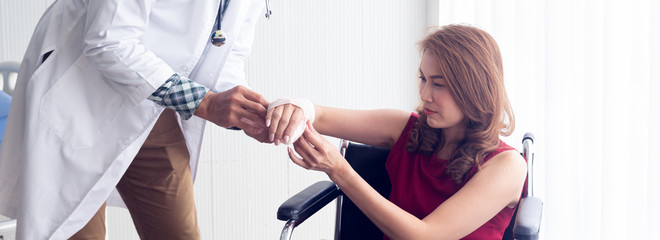 A female Asian patient suffered an accident with her arm broken, causing her to sit in a wheelchair...