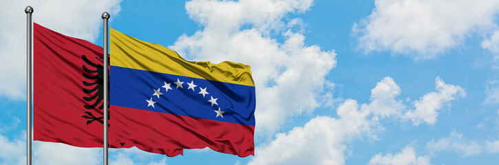 Albania and Venezuela flag waving in the wind against white cloudy blue sky together. Diplomacy concept, international relations.