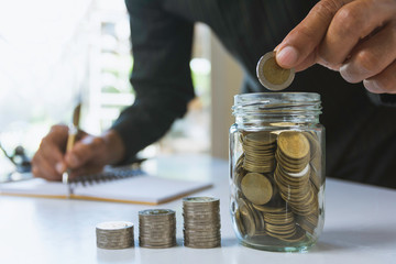 Hand drop a coin with money coin stack growing for business. financial and accounting concept.