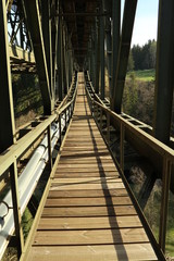 Fototapeta na wymiar Eisenbahnbrücke mit Fußgängerüberweg an sonnigem Tag