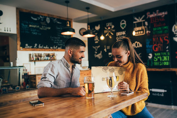 couple ordering food looking at menu in food corner bar