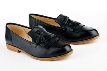 Women's black ballet flats on white background.