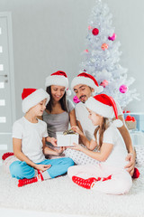 Fototapeta premium Happy parents and children near Christmas tree at home