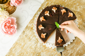 Obraz na płótnie Canvas Delicious caramel chocolate tart with mint leaf on top. Top view of finest mascarpone cake.