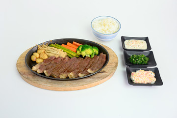 Japanese wagyu beef slices set with vegetables and sauce on pan