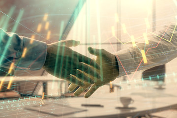 Multi exposure of financial graph on office background with two businessmen handshake. Concept of success in business