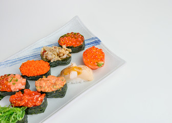 Japanese sushi of seaweed roll with Ikura, Ebiko, Hotate, Wakame, Kurage on ceramic plate