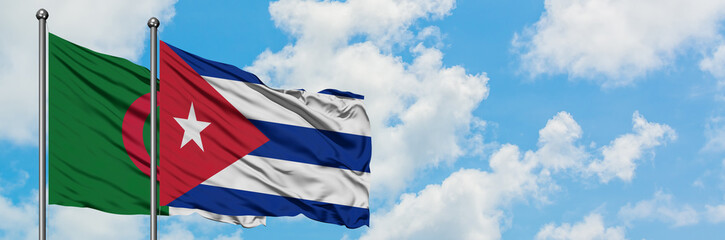 Algeria and Cuba flag waving in the wind against white cloudy blue sky together. Diplomacy concept, international relations.