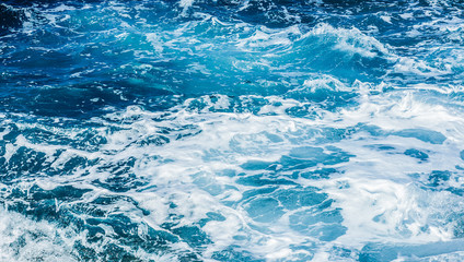 Rough sea or ocean foam. Blue salt water waves background.