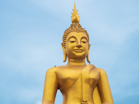 Big golden buddha statue against blue sky. Travel asia Thailand.