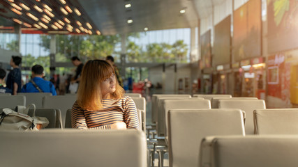 A beautiful woman is waiting for the plane to travel. Travel concept