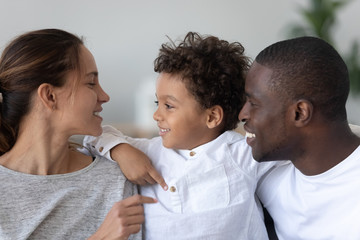 Happy multiethnic family of three have fun at home