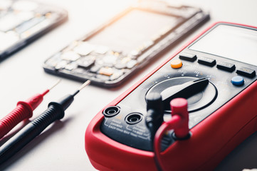 The inside of the smartphone's motherboard and tools lay on the back table. the concept of computer...