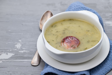 typical portuguese soup caldo verde in white bowl on ceramic background