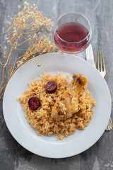 chicken with smoked sausage and rice on white plate