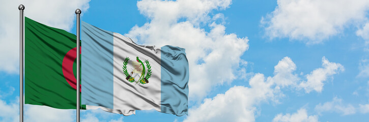 Algeria and Guatemala flag waving in the wind against white cloudy blue sky together. Diplomacy concept, international relations.