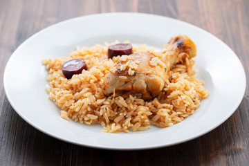chicken with smoked sausage and rice on white plate
