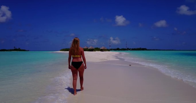 lady in bikini taking her step on crystal clear water of an island in philippines, tracking shot
