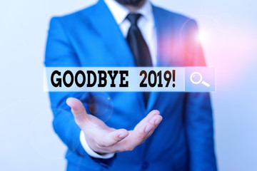 Writing note showing Goodbye 2019. Business concept for express good wishes when parting or at the end of last year Man in front of table. Mobile phone and notes on the table