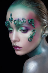 young beautiful girl with creative make-up of green and purple flowers