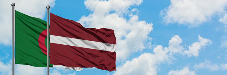 Fototapeta na wymiar Algeria and Latvia flag waving in the wind against white cloudy blue sky together. Diplomacy concept, international relations.