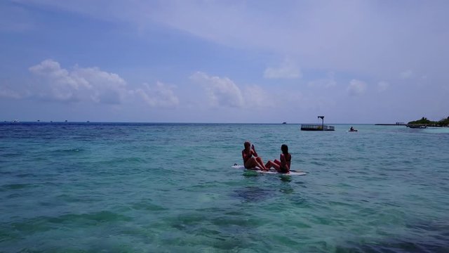 Pretty young girls on a paddle board in Maldives