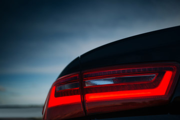 Modern car rear taillight lamp in the front of sky