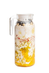 Closeup jug of homemade layered smoothie of mango, passion fruit, oats, chia seeds, banana, goji berries and coconut milk isolated at white background. vegan superfood and healthy lifestyle.