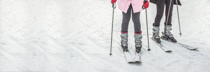 Woman legs in ski boots on snow landscape with copy space, travelling vacation concept.