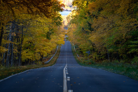 Road Through The Porcupine Mountains In The Upper Peninsula In Michigan During The Fall. Concept For Fall Leaf Peeping Road Trip