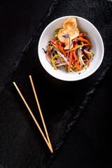 Asian with miso pasta, soy sauce, herbs. On a black stone table, with chopsticks. Copy top view