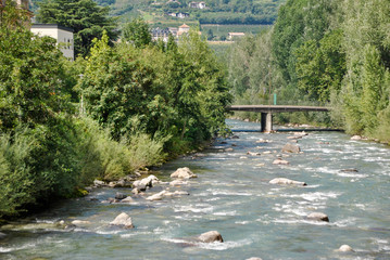 a river with fast flowing water and a bridge