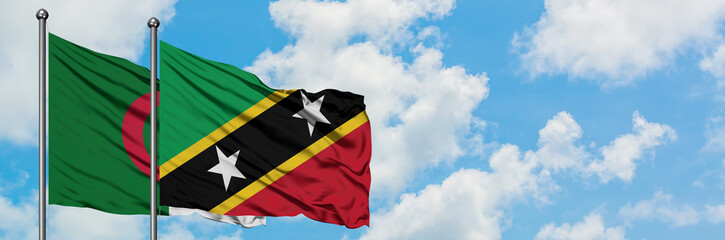 Algeria and Saint Kitts And Nevis flag waving in the wind against white cloudy blue sky together. Diplomacy concept, international relations.