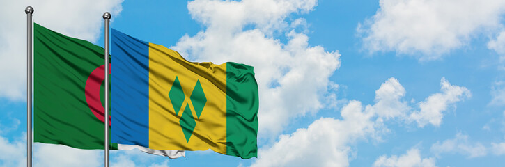 Algeria and Saint Vincent And The Grenadines flag waving in the wind against white cloudy blue sky...