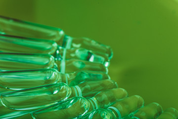 Glass medical ampoule vial for injection. Medicine is liquid sodium chloride with of aqueous solution in ampulla. Close up. Bottles ampule multicolor.