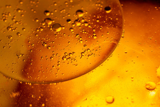 Abstract colorful background. Foam of Soap with Bubbles macro shot. Closeup bubbles in water. Oil drops on a water surface abstract background. Golden yellow bubble.Yellow water bubbles wallpaper