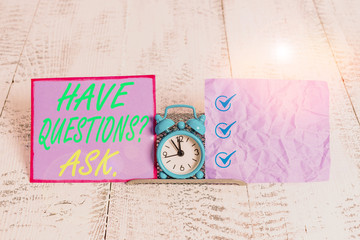Text sign showing Have Questionsquestion Ask. Business photo text something that you say or write to ask a demonstrating Mini blue alarm clock standing above buffer wire between two notation paper