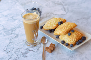 prepares coffee with milk with ciabatta in his coffee shop