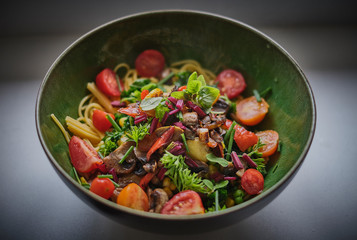 Healthy pasta salad in a green bowl