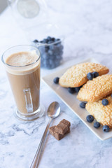 prepares coffee with milk with ciabatta in his coffee shop