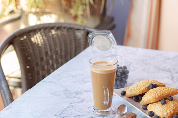 prepares coffee with milk with ciabatta in his coffee shop