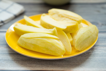 Sliced sour yellow mangoes on yellow dish