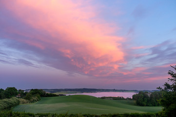 View on Helgenæs in Denmark at sunset with pink clouds and sky