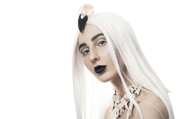 Beautiful woman with bone jewelery in white wig with stylish makeup, black lips, white eyeliner and mascara on isolated white background. Halloween look concept