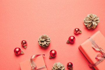 Christmas composition. Gift, christmas red decorations, pine cones on red background.