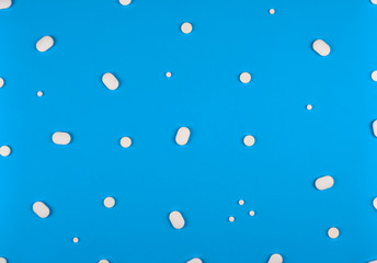 Medical background. Pills pattern on blue background