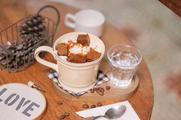 Hot chocolate. A cup of hot chocolate with selective focus on the whipping cream and caramel sauce.