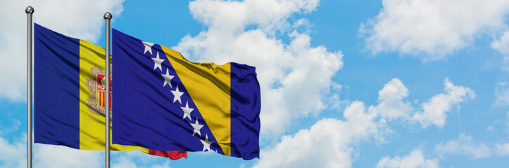 Andorra and Bosnia Herzegovina flag waving in the wind against white cloudy blue sky together. Diplomacy concept, international relations.