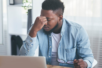 Exhausted black employee tired of long time work in office